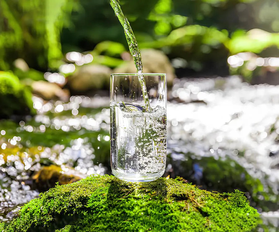 Pouring clean natural spring water into a glass.